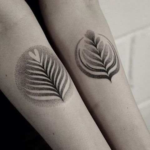 two tattoos on the arms of people with leaves and dots in them, one is black and white