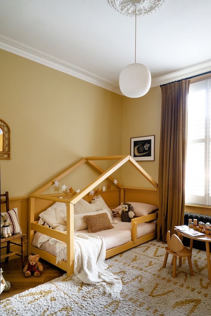 a child's room with a bed, table and chairs