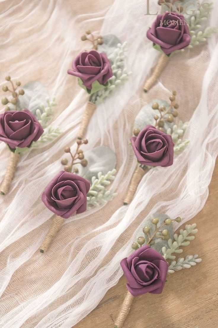 purple flowers are arranged on top of white fabric