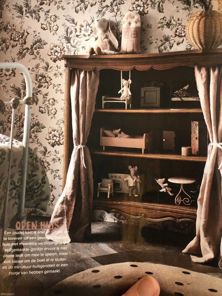 an old fashioned book shelf with curtains on it