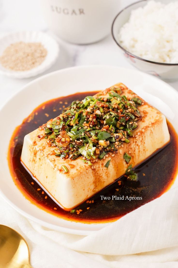 a white plate topped with tofu covered in sauce