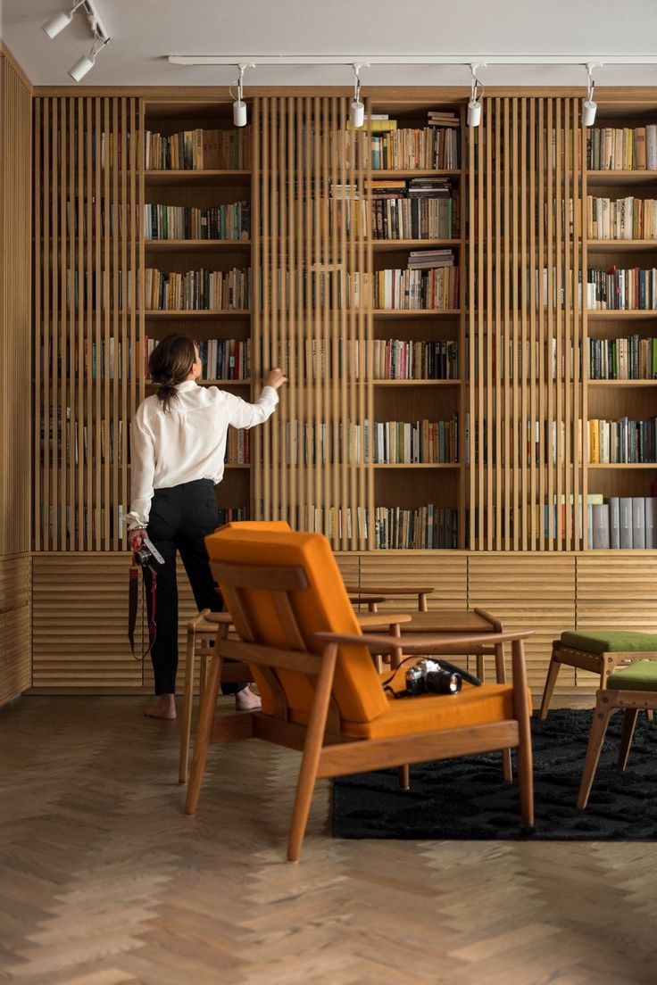 a woman standing in front of a bookshelf filled with shelves full of books