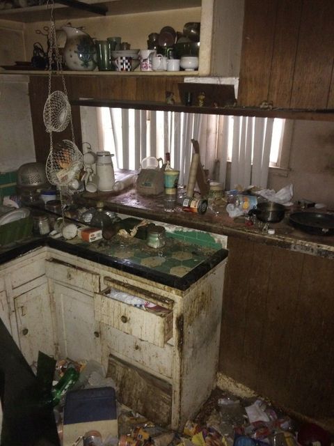 an old kitchen with lots of clutter on the floor