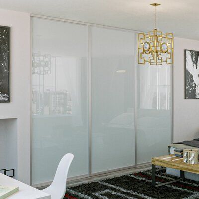 a bedroom with white walls and black rugs on the floor next to a bed