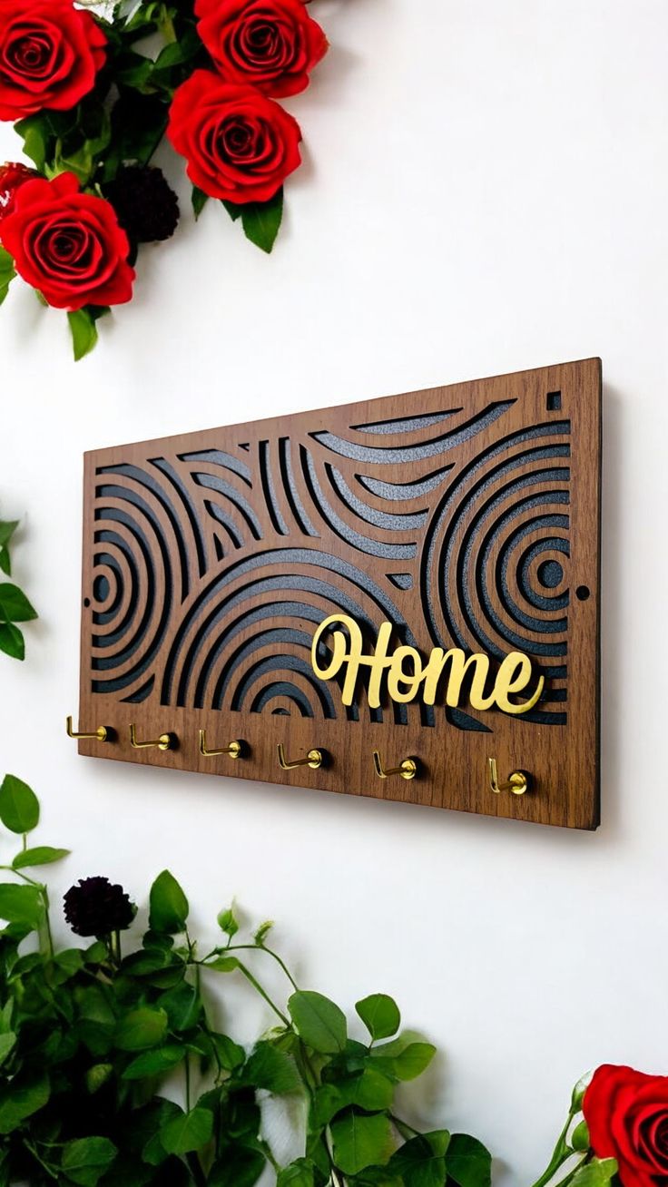 a wooden sign with the word home written on it next to red roses and greenery