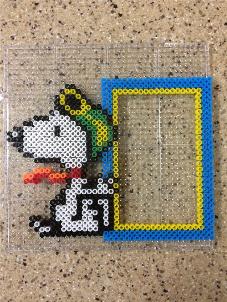 a beaded picture frame with a dog on the front and side, sitting next to it