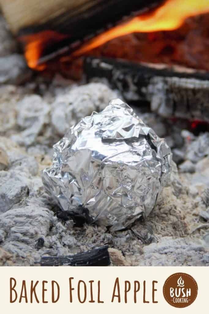 a piece of tin foil sitting on top of a rock next to an open fire