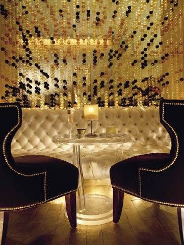 two chairs sitting next to each other in front of a wall with gold sequins