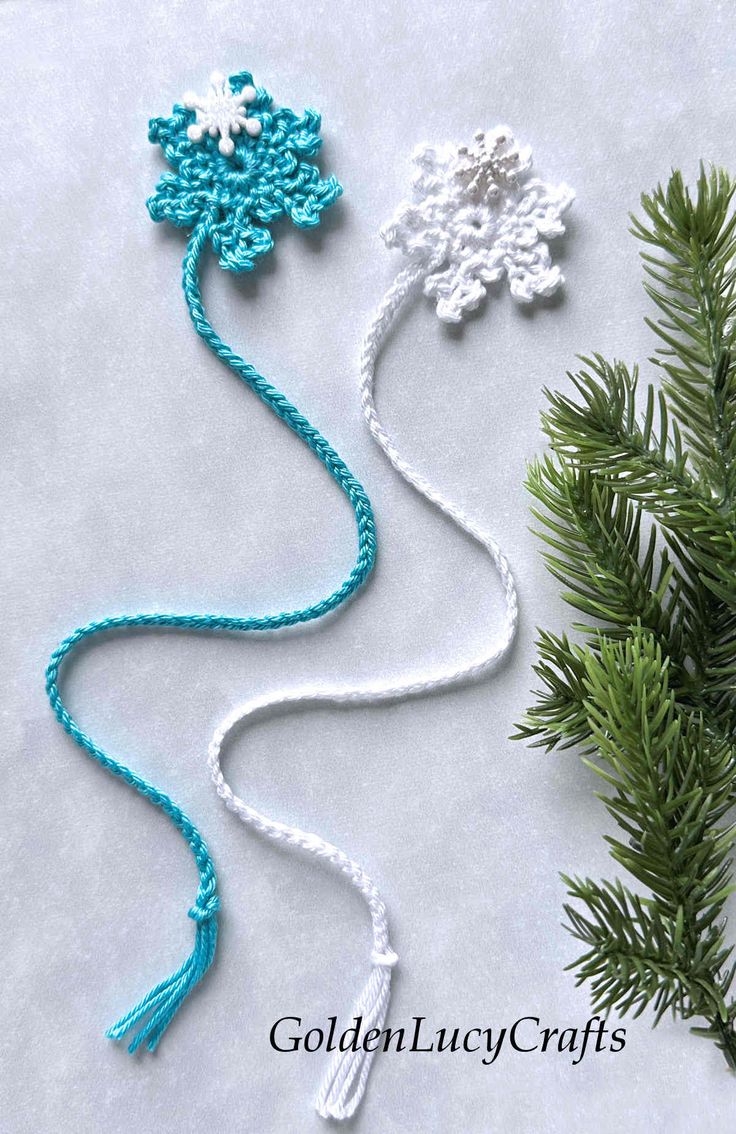 three crocheted snowflakes are shown next to a pine tree