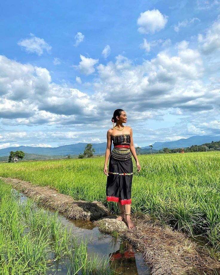 a woman standing in the middle of a field