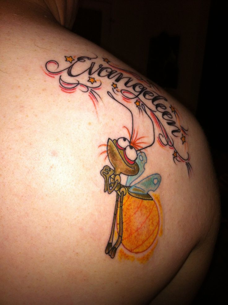 the back of a woman's shoulder with an orange and yellow tattoo on it