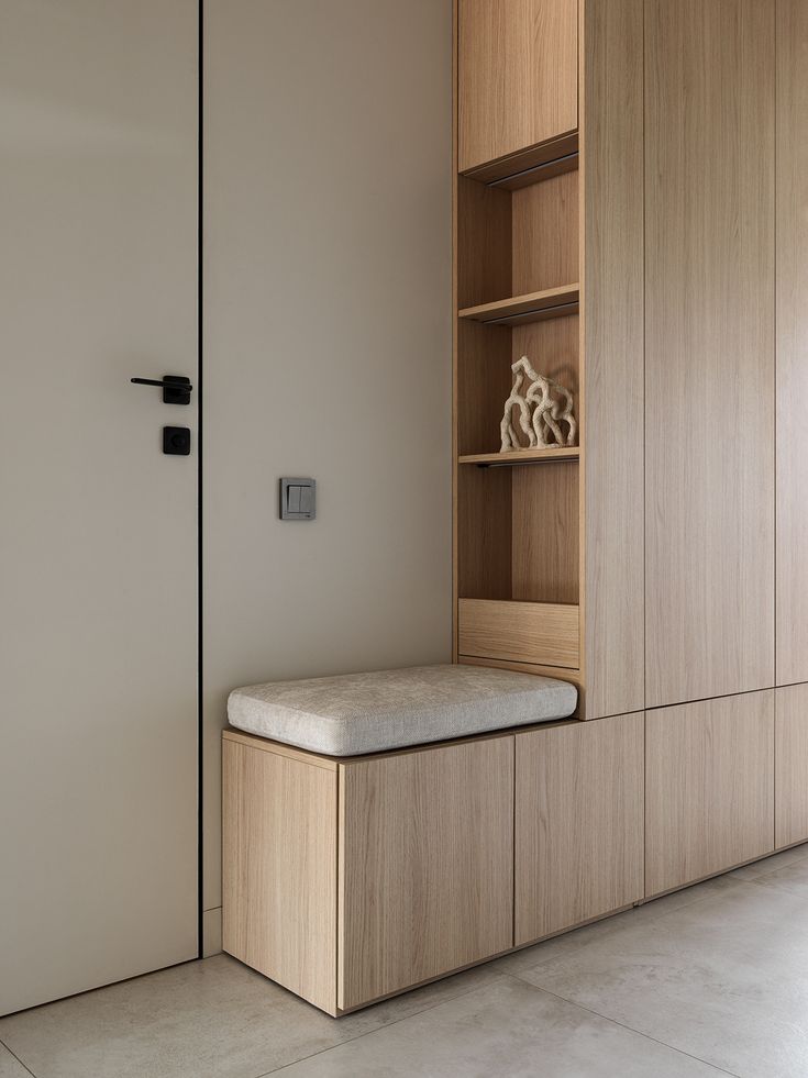 a wooden shelf sitting next to a white wall in a room with tile flooring