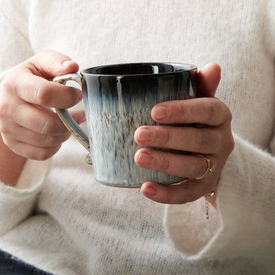 a woman holding a coffee cup in her hands