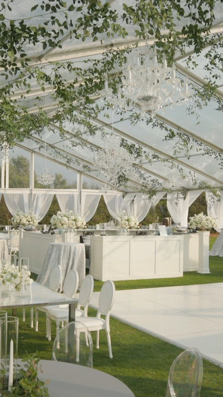 an outdoor venue with tables and chairs set up for a formal function in the grass