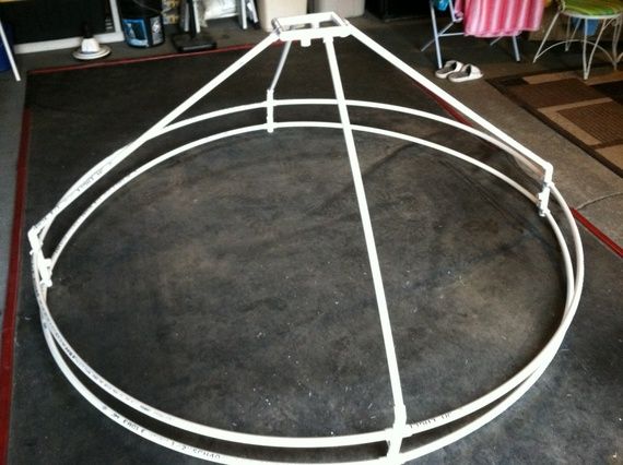 a large white metal object sitting on top of a black floor next to tables and chairs