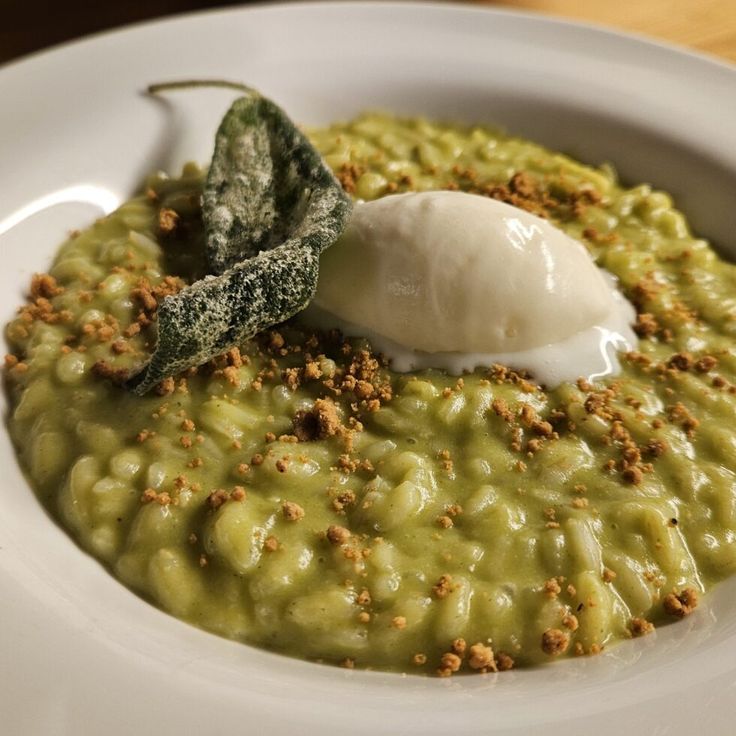 a white bowl filled with green food and garnish