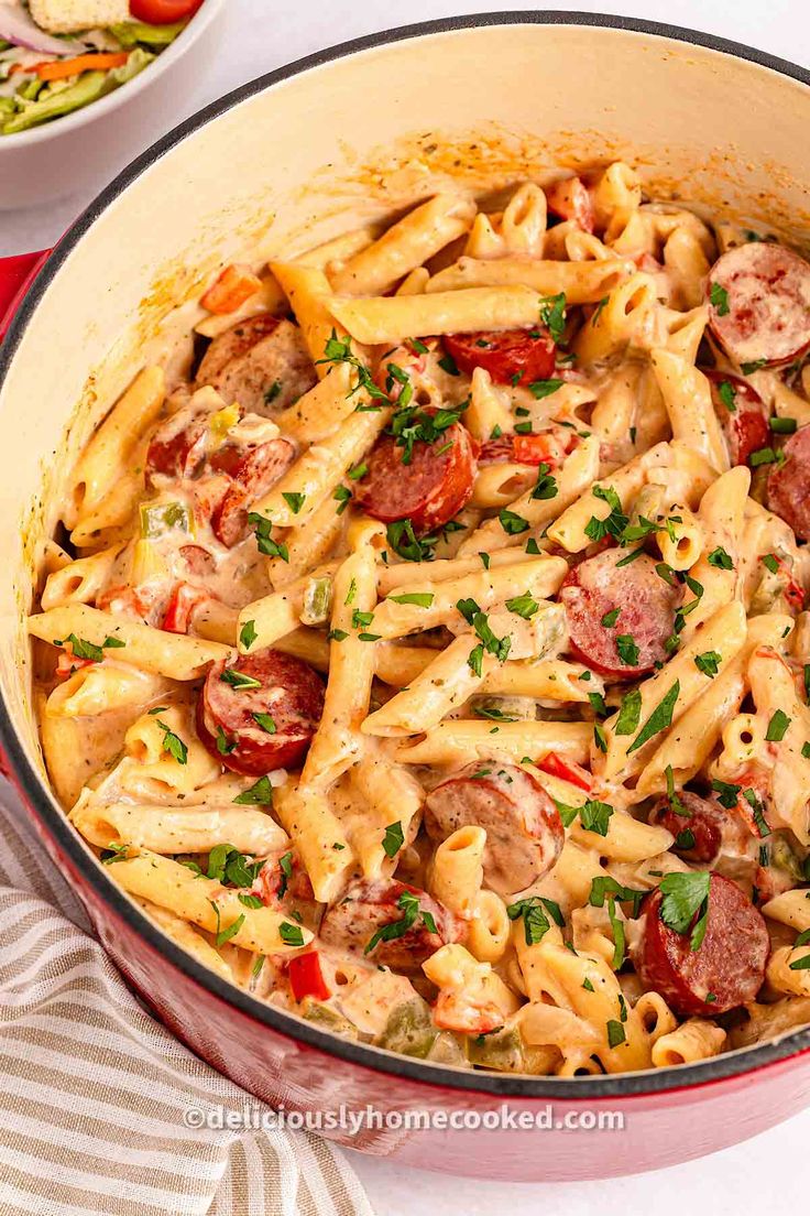 a pan full of pasta with sausage and tomatoes