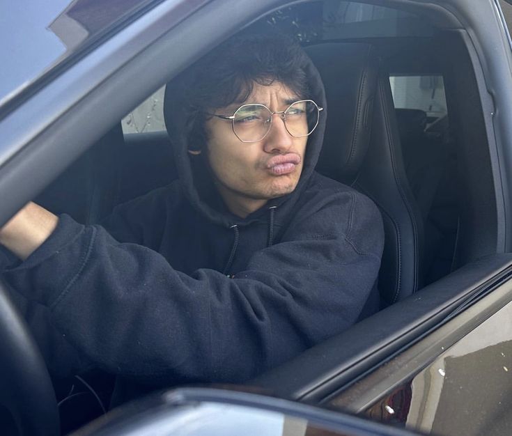 a man sitting in the driver's seat of a car