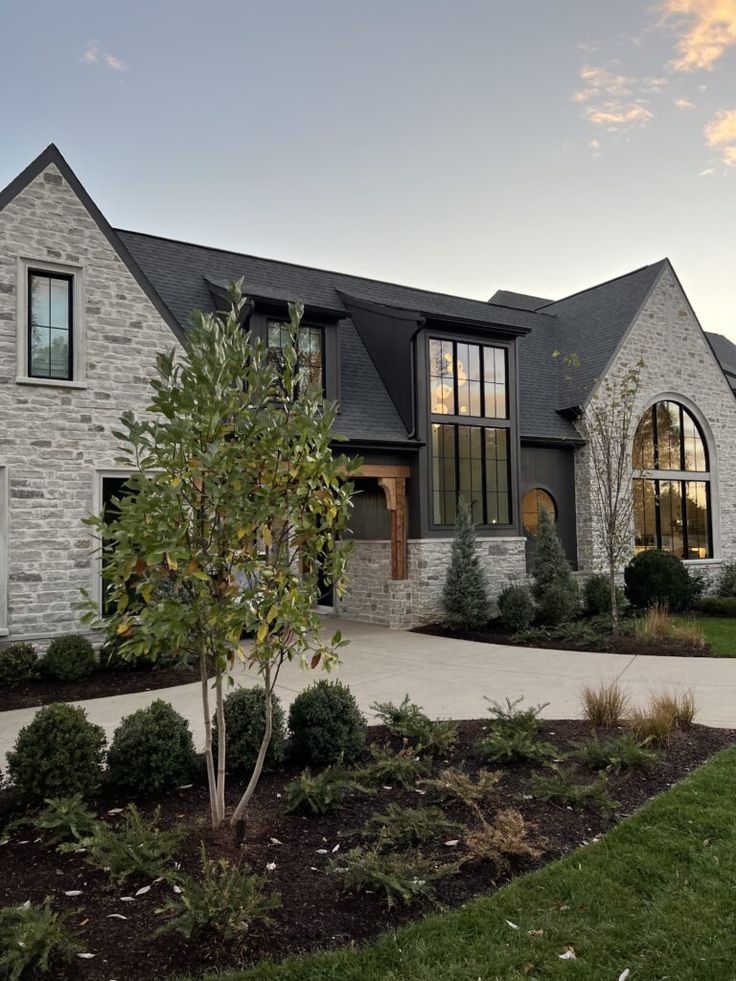 a large brick house with lots of windows on the front and side of it's roof