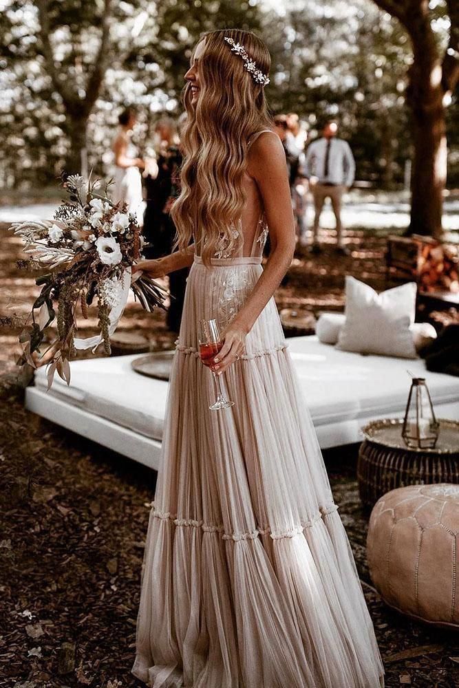 a woman in a wedding dress standing next to a bed