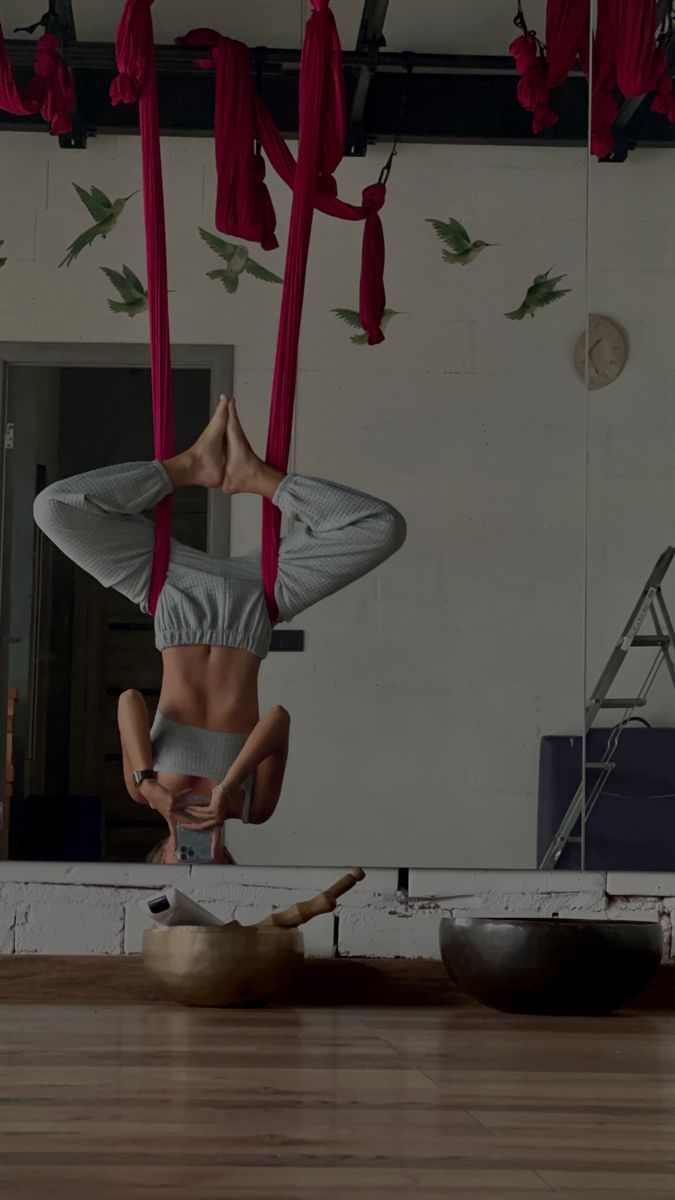 a woman doing aerial acrobatic tricks in a room