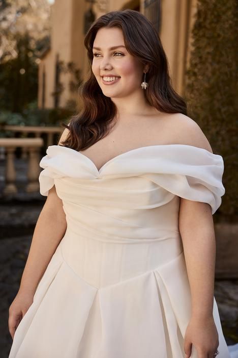 a woman in a white dress posing for the camera with her hands on her hips