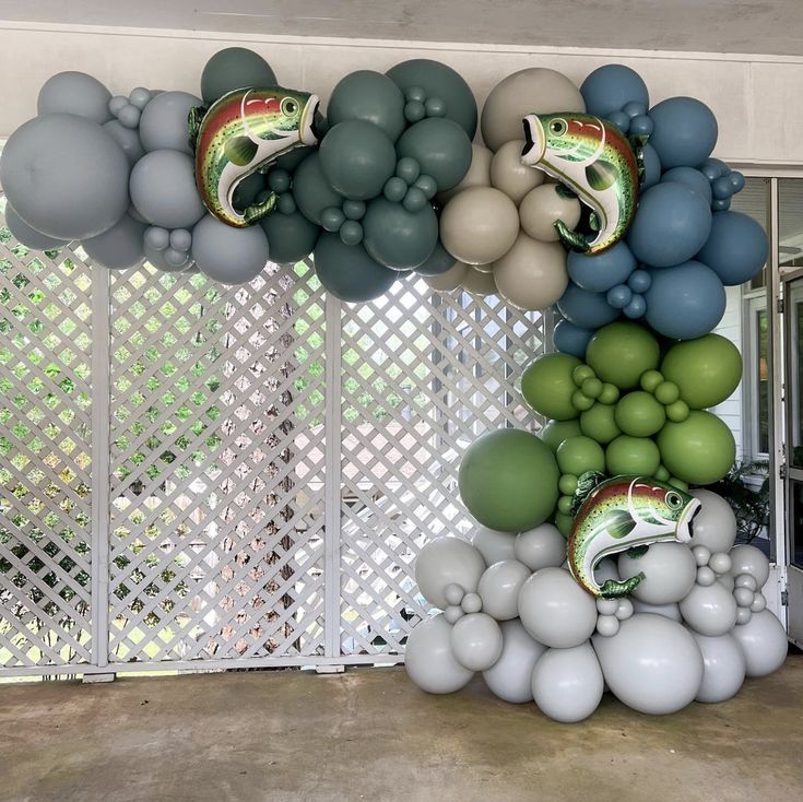 some balloons are hanging from the ceiling in front of a wall with fish on it