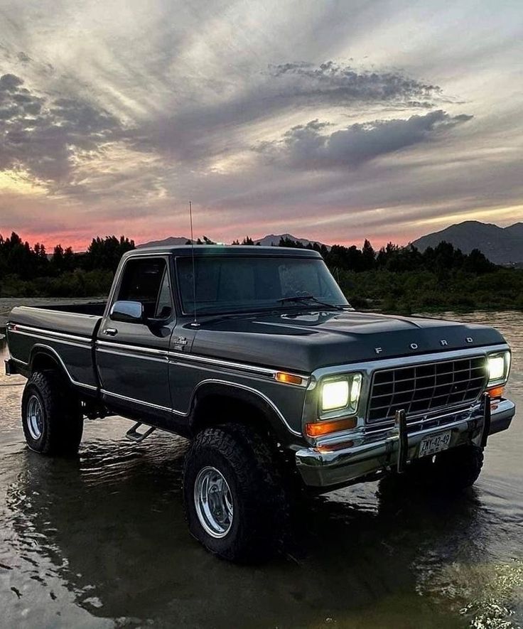 the truck is parked in the shallow water