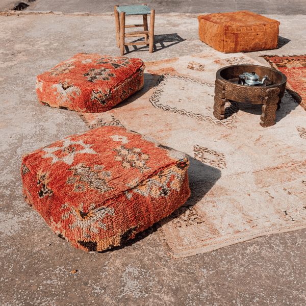 an old rug and two stools on the ground