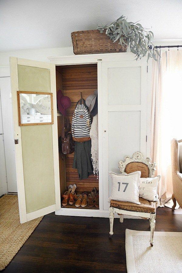 an open closet with shoes and other items in the corner, next to a chair