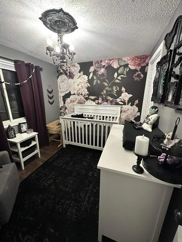 a baby's room decorated in black and white with flowers on the wall, crib