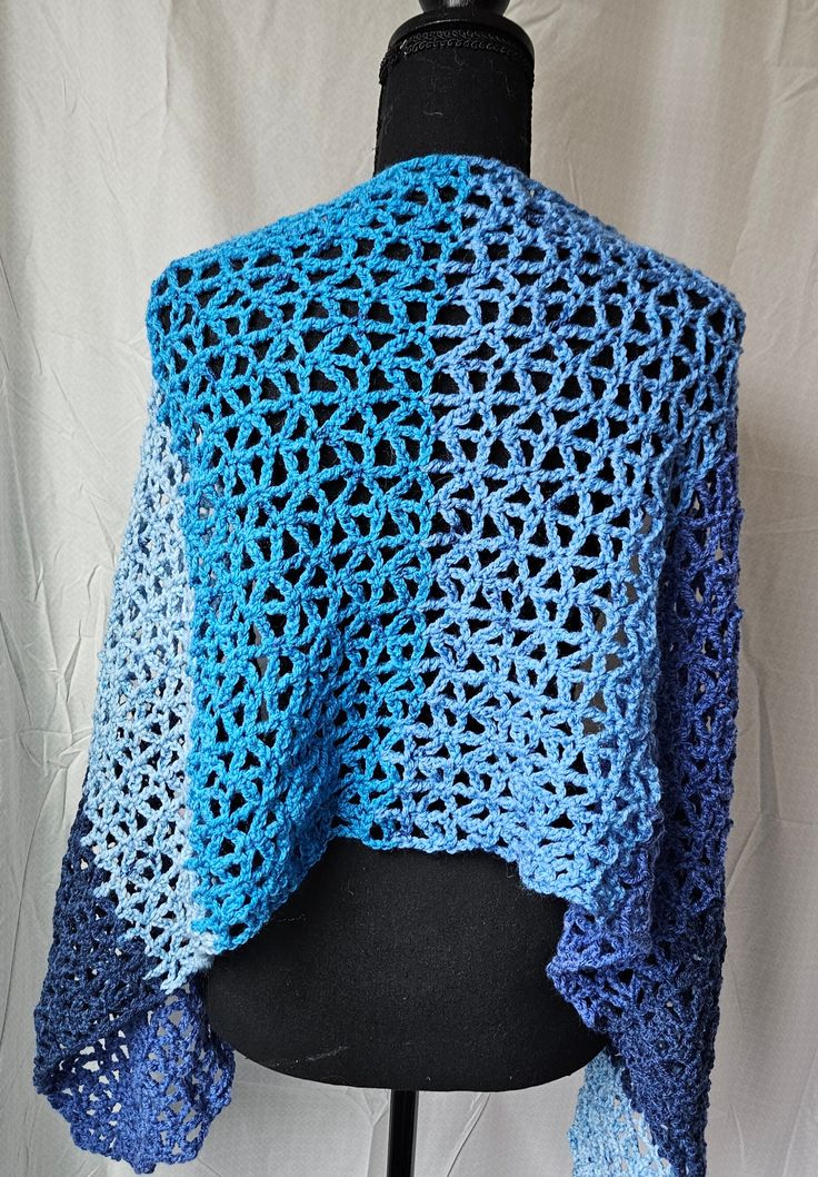 This is a light weight wrap which can also be worn as an oversized scarf.  It is hand-crocheted and the pattern is open, which makes this lightweight.  The yarn is very soft but durable, and this will keep you warm and look gorgeous. Approx. 52" long and 16" wide Made with Caron Cakes Yarn, 80% Acrylic, 20% Wool. Machine wash/dry One Size Blue Shawl For Beach, Crochet Lace Shawl For Winter, One Size, Hand Knitted Yarn Shawl Scarf, Crochet Lace Shawl One Size For Winter, Blue Knitted Yarn Scarves, Blue Knitted Yarn Scarf, One Size Crochet Lace Shawl For Winter, Winter Crochet Lace Shawl One Size, Blue One Size Shawl For Winter