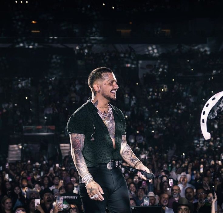 a man standing on top of a stage in front of a crowd