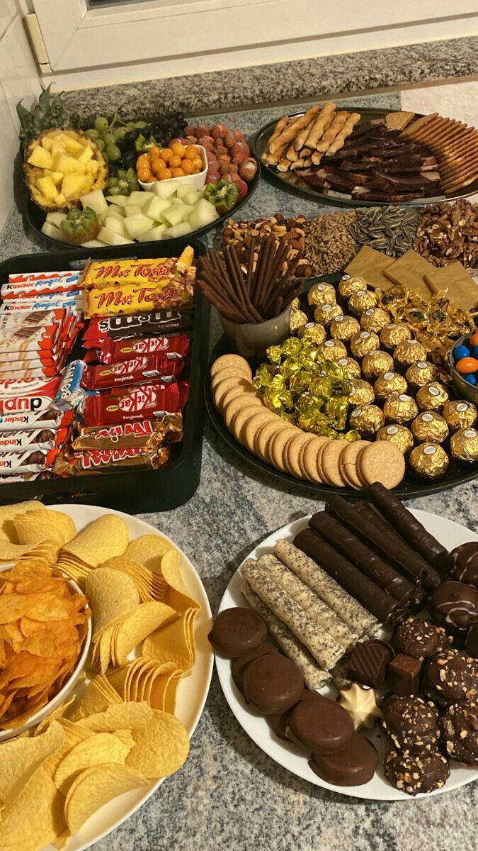 a table filled with lots of different types of snacks on plates next to each other