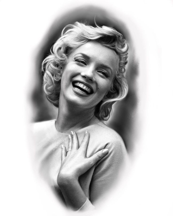 a black and white photo of a woman with her hands on her chest smiling at the camera