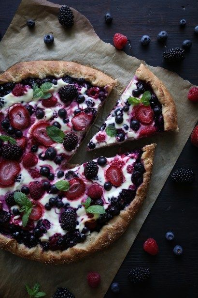 there is a pizza with berries and cream on it