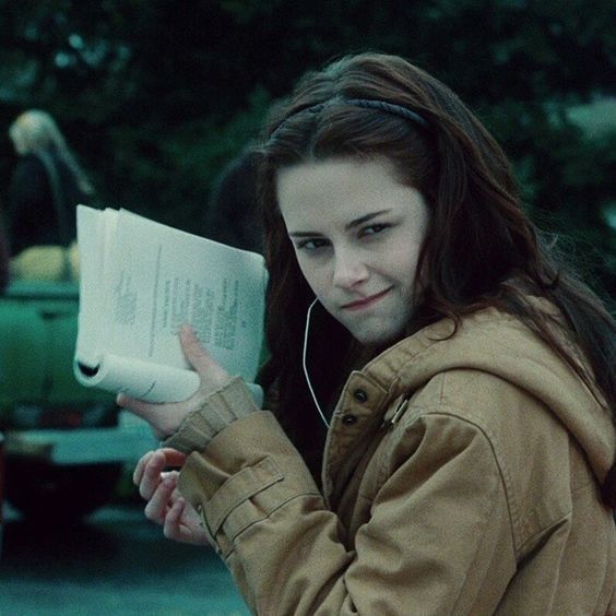 a young woman is reading a book and listening to headphones while holding her hand out