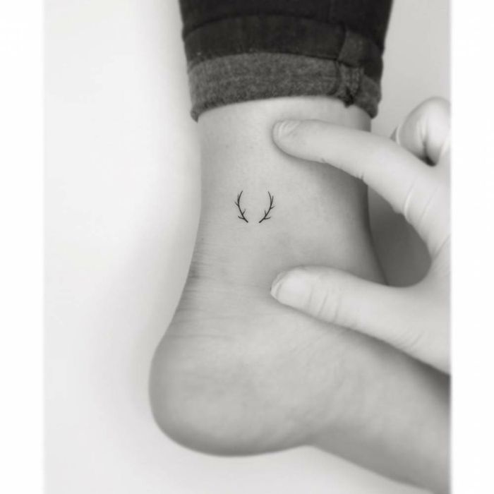 a woman's foot with a small tattoo on it