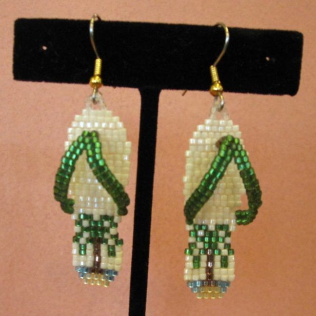 the beaded earrings are hanging on a black stand