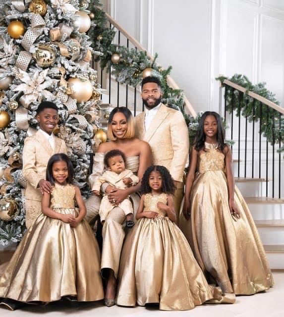 a family posing in front of a christmas tree