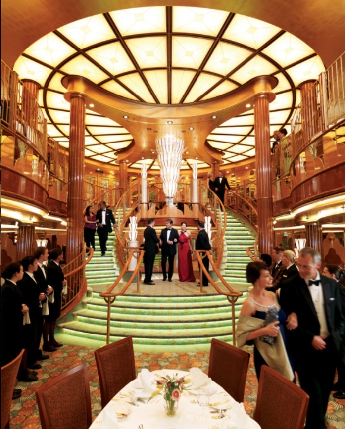 a large dining room with many people on the stairs