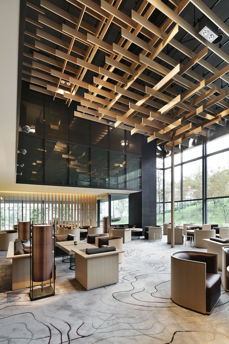 an empty room with lots of tables and chairs in the center, surrounded by large windows