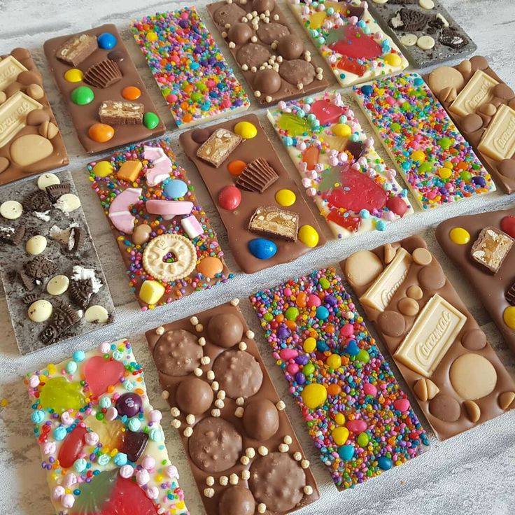 many different types of candies and chocolates are arranged in rows on the table