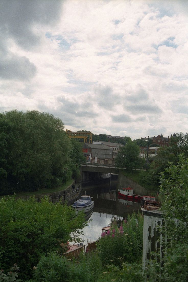 two boats are docked on the river under a bridge