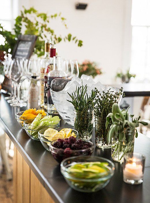 the bar is full of wine glasses, fruit and herbs