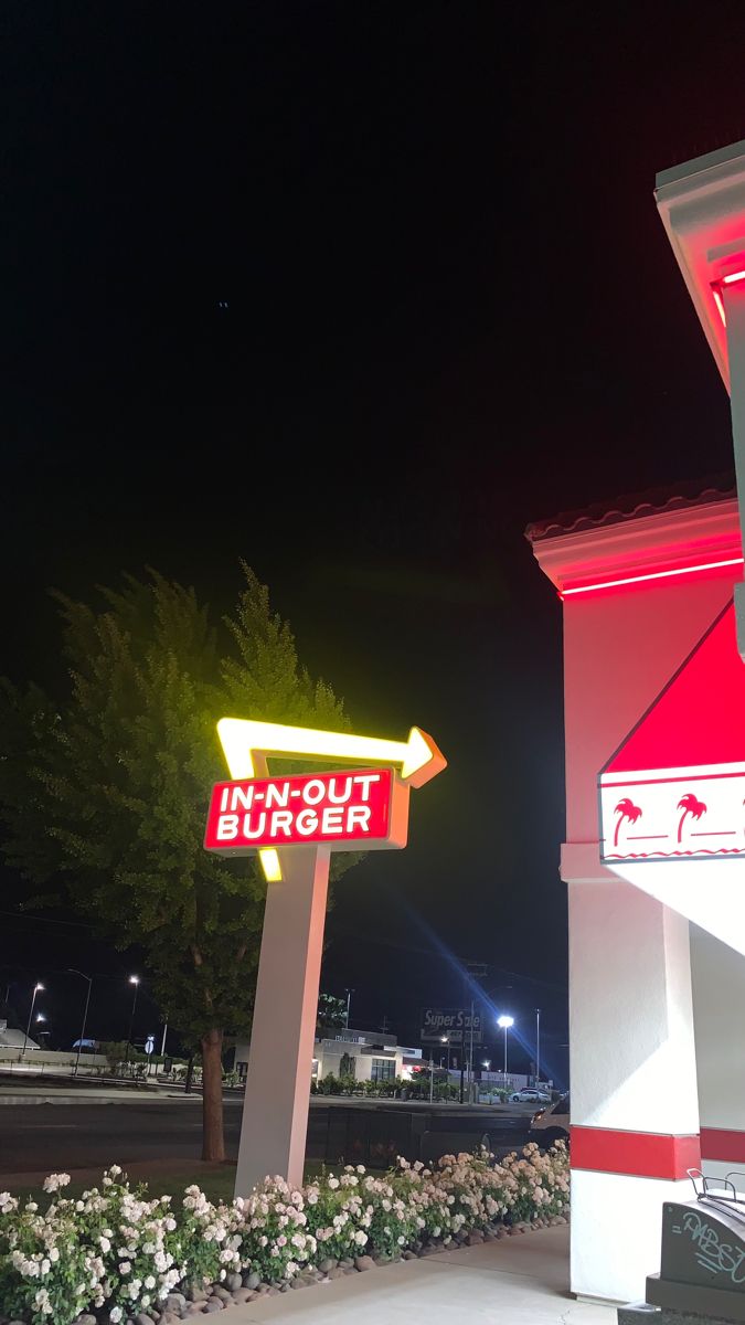 a red and white building with a sign that says out in the bush on it