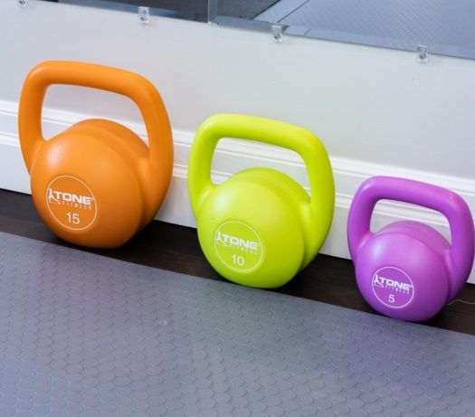 three different colored kettles sitting next to each other on the floor in front of a wall