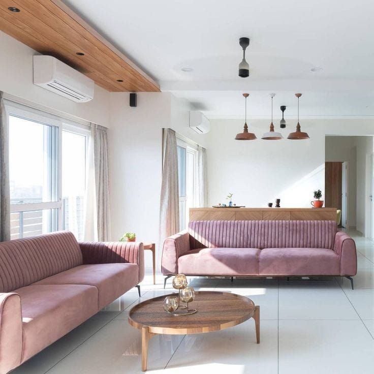 a living room with two couches and a coffee table in front of large windows