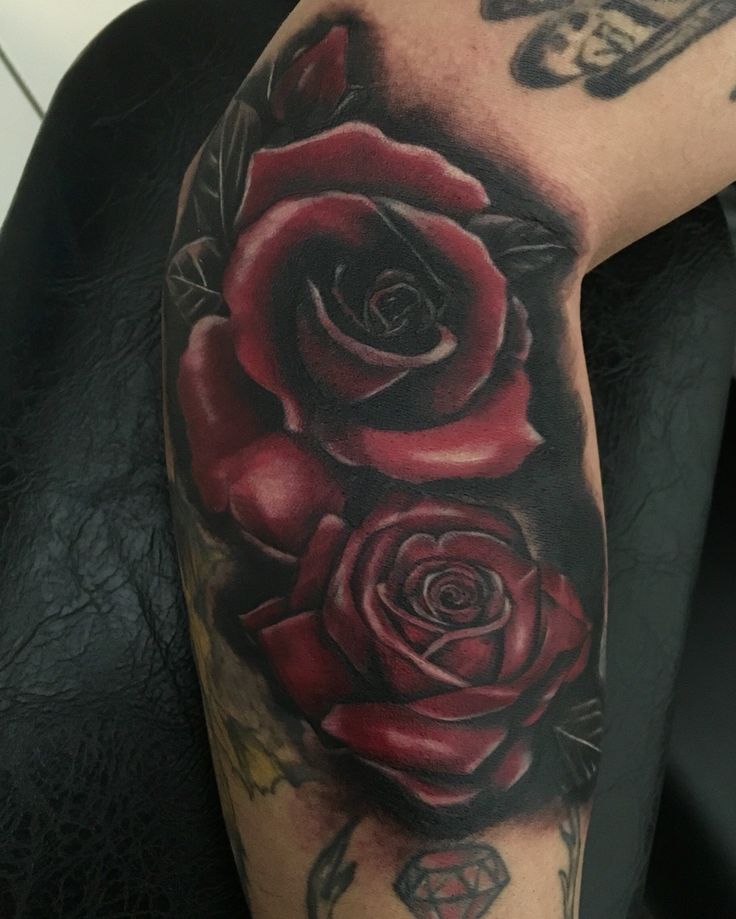 a man with a rose tattoo on his arm