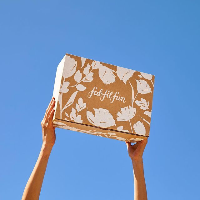 a person holding up a box with the word leaf fun written on it in front of a blue sky